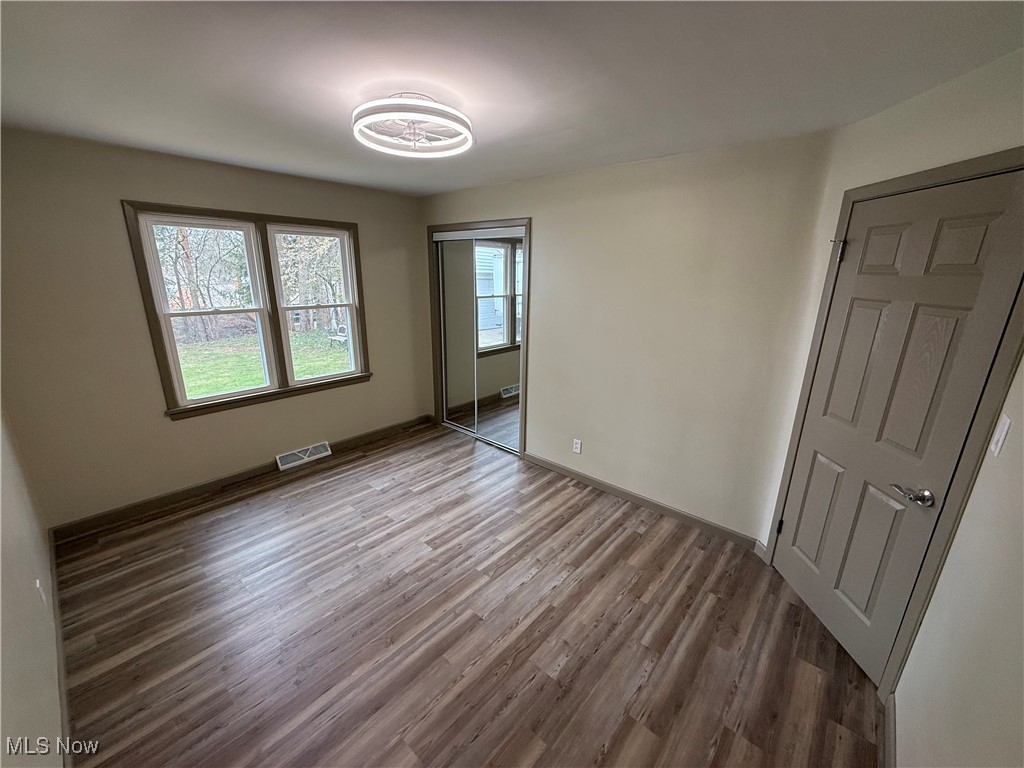 9417 Alexander Road Garfield Heights, OH 44125 - Photo 19 of 38 Unfurnished bedroom featuring visible vents, baseboards, a closet, and wood finished floors