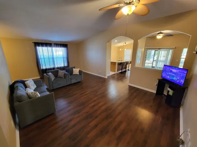 a living room with furniture and wooden floors