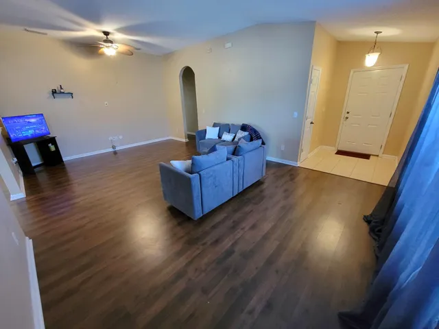 a living room with furniture and a wooden floor