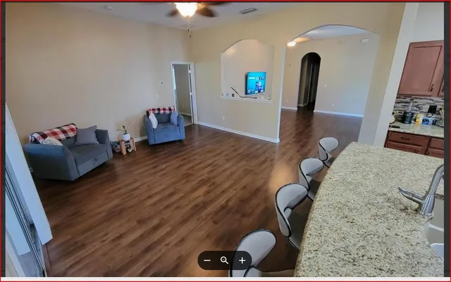a living room with couches and a large mirror with wooden floor