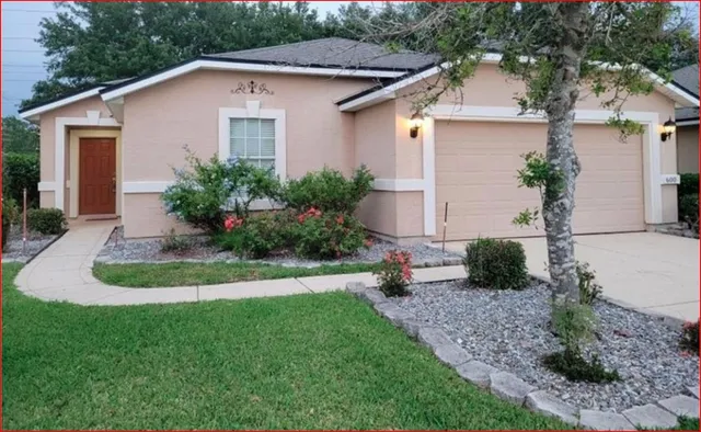 a view of backyard of house with green space