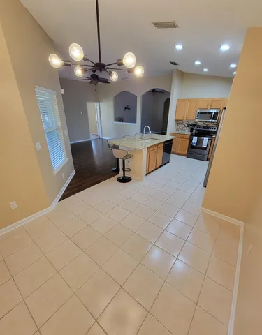 a large room with kitchen view and a chandelier