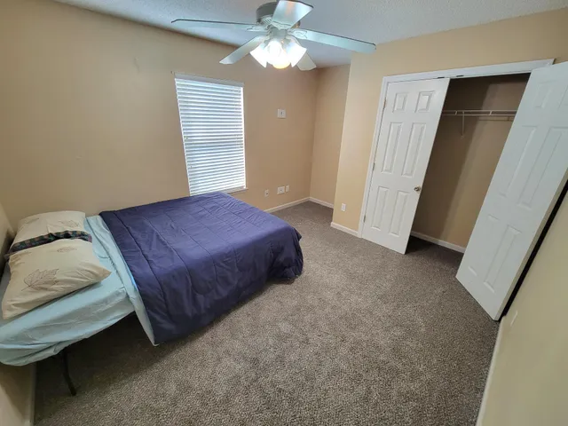 a spacious bedroom with a bed and a chandelier