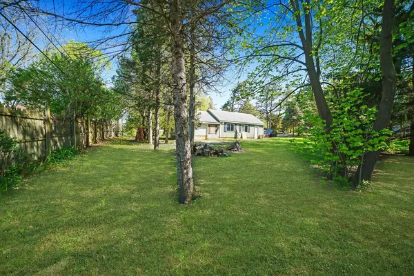 an aerial view of residential house with outdoor space and trees all around