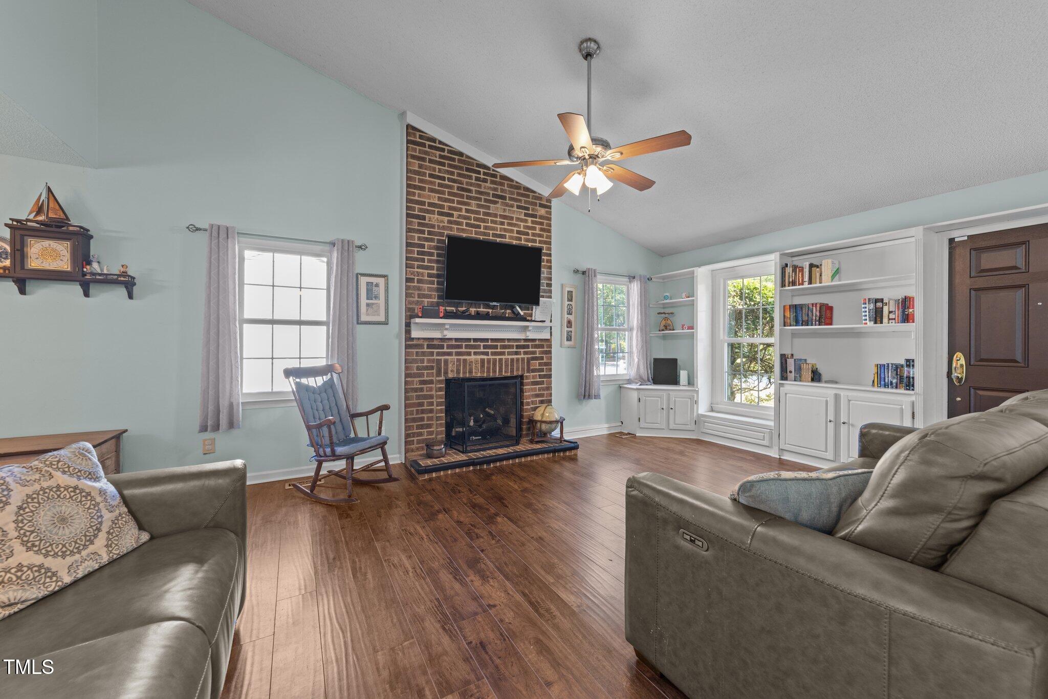 11901 North North Exeter Way Way Raleigh, NC 27613 - Photo 6 of 39 a living room with furniture a flat screen tv and a fireplace