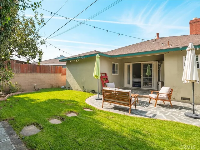 a view of backyard of house with outdoor seating and green space