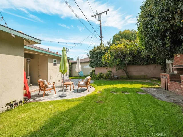 a view of a backyard with couches plants and large tree