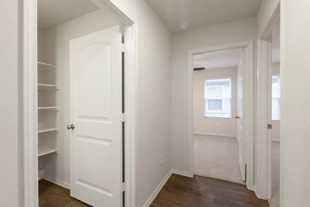 a view of a hallway with wooden floor