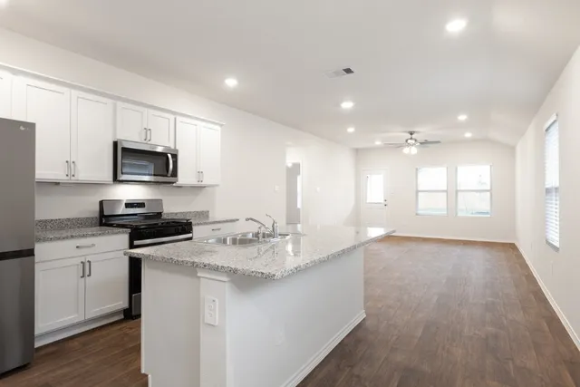 a kitchen with a sink a microwave and cabinets