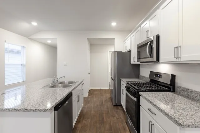 a kitchen with stainless steel appliances granite countertop a sink stove and refrigerator