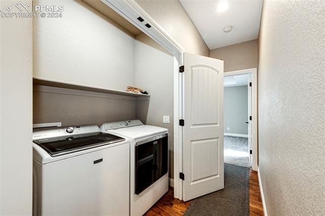 711 Pine Ridge Street Elizabeth, CO 80107 - Photo 26 of 39 Washroom featuring dark hardwood / wood-style flooring and washing machine and clothes dryer