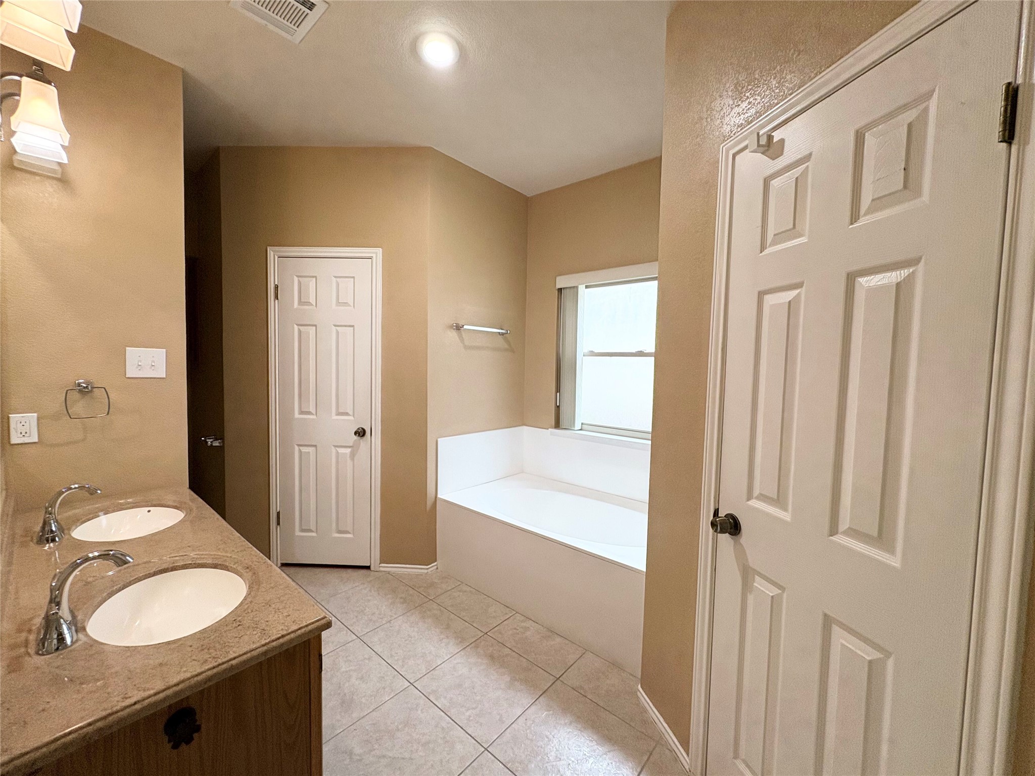 8103 Ephraim Road Austin, TX 78717 - Photo 30 of 35 A well-appointed bathroom offers a double vanity and a built-in tub for ultimate relaxation.