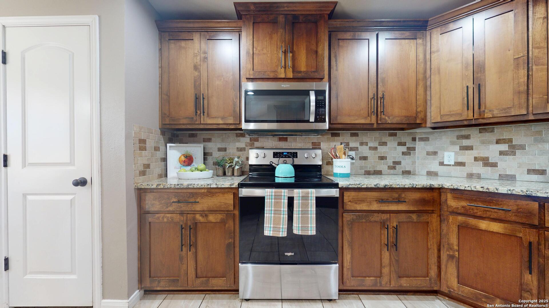3992 Fm 1784 Pleasanton, TX 78064 - Photo 13 of 38 a kitchen with granite countertop wooden cabinets and a sink
