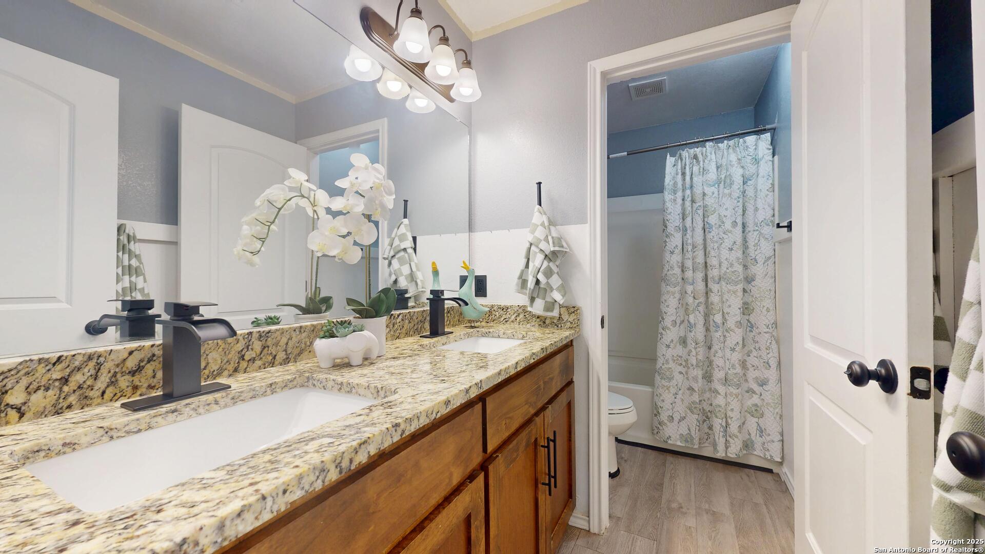 3992 Fm 1784 Pleasanton, TX 78064 - Photo 18 of 38 a bathroom with a granite countertop sink a mirror a vanity and shower