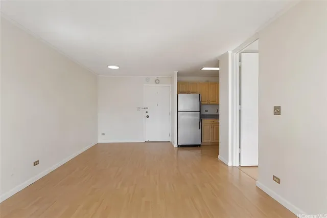 a view of empty room with a kitchen