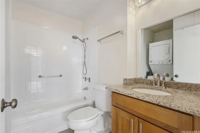 a bathroom with a granite countertop sink a mirror toilet and bathtub