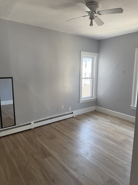 40 Rogers Avenue, Unit 2 Lynn, MA 01902 - Photo 11 of 15 an empty room with wooden floor fan and windows