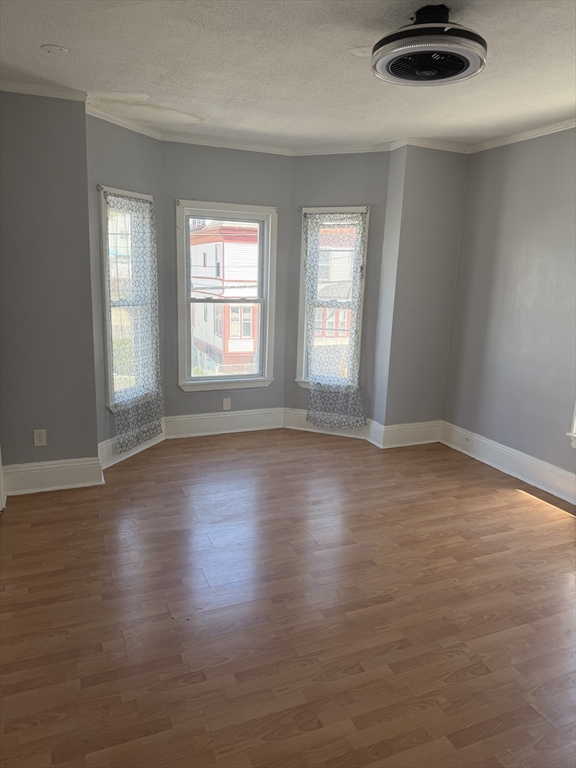 40 Rogers Avenue, Unit 2 Lynn, MA 01902 - Photo 15 of 15 an empty room with wooden floor and windows