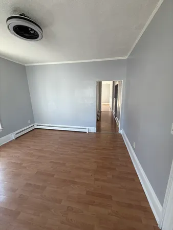 a view of an empty room with wooden floor