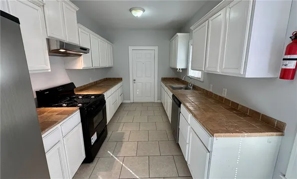a kitchen with granite countertop a sink stove and cabinets