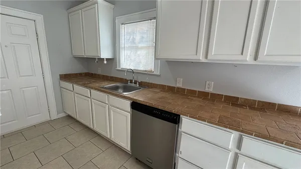 a kitchen with stainless steel appliances granite countertop a sink and a white cabinets