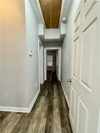 a view of a hallway with wooden floor and staircase