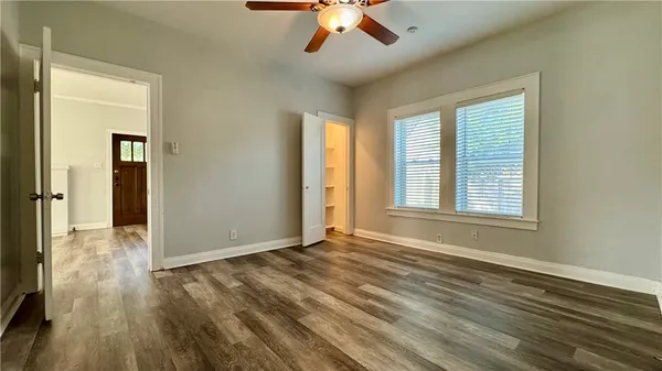 a view of an empty room with window and wooden floor