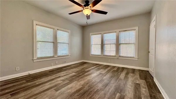 a view of an empty room with chandelier fan and a window