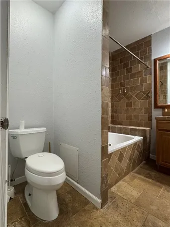 a bathroom with a toilet and bathtub