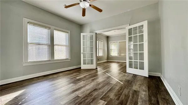 a view of an empty room with a window and wooden floor