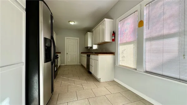 a kitchen with a sink a refrigerator and cabinets