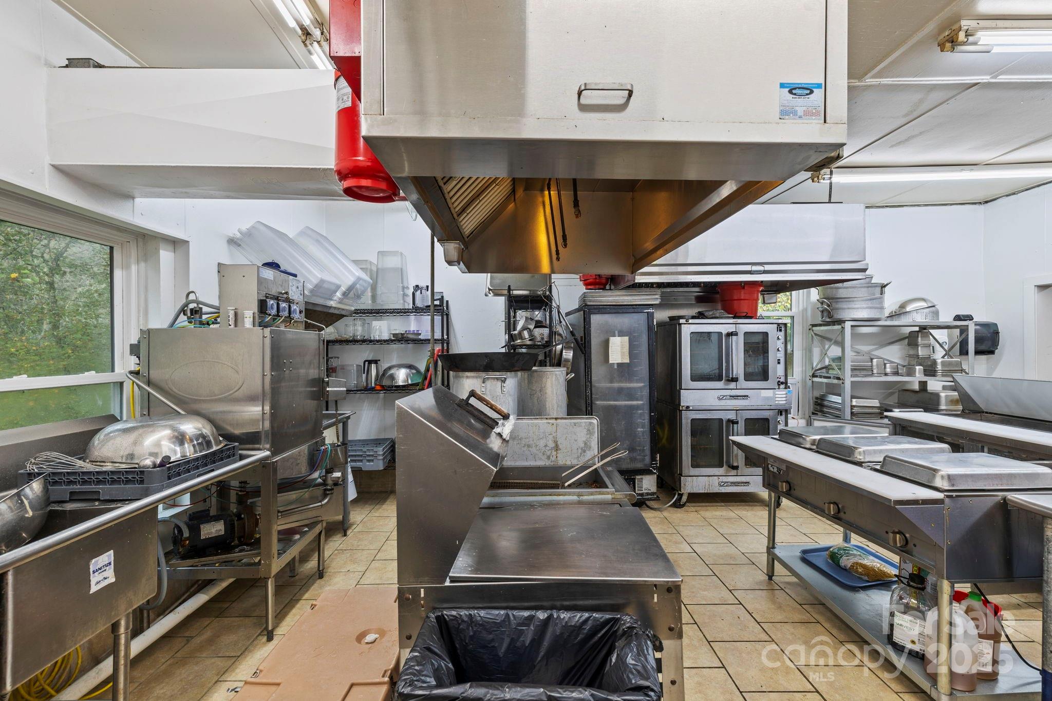 1196 North Country Club Road Brevard, NC 28712 - Photo 12 of 48 a kitchen with stainless steel appliances granite countertop a stove and white cabinets