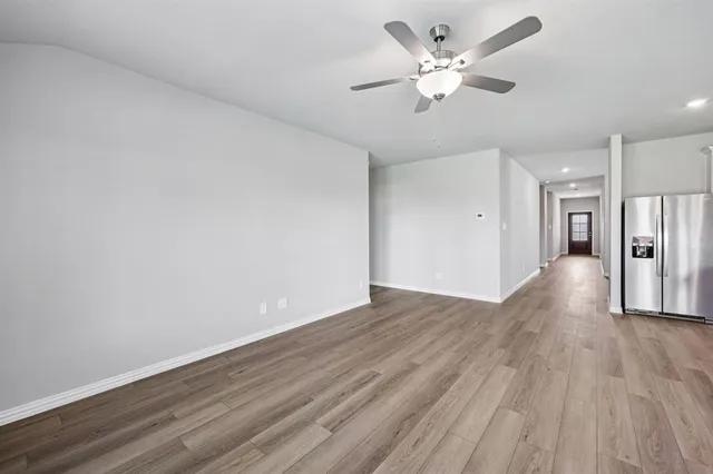 a view of an empty room with wooden floor