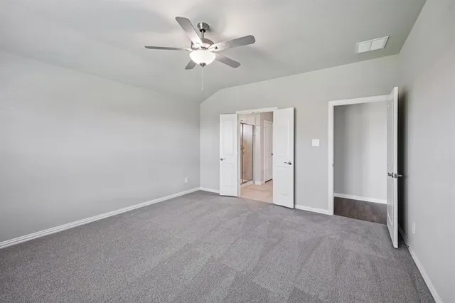 a view of an empty room with a chandelier fan