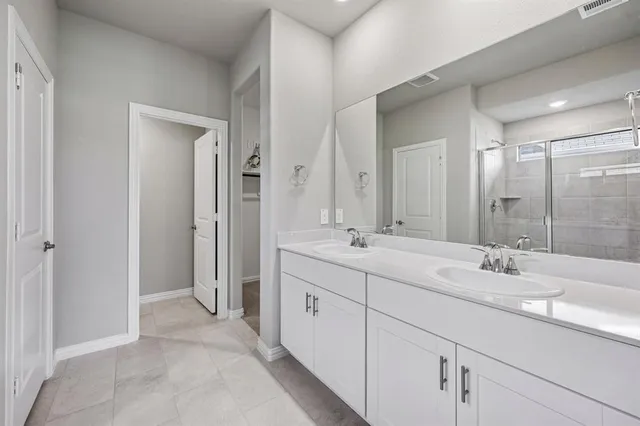a bathroom with double sink and a mirror