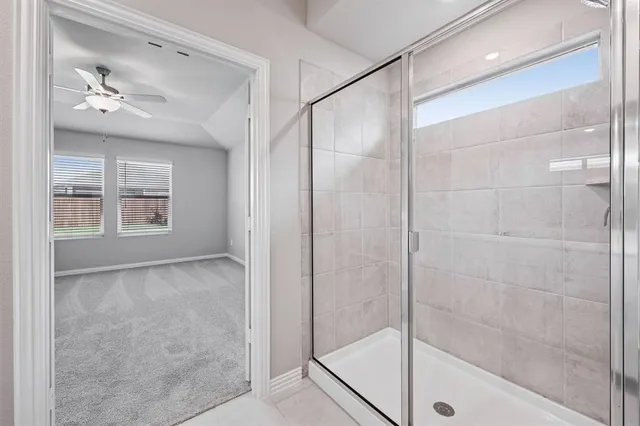 a bathroom with a glass shower door and a window