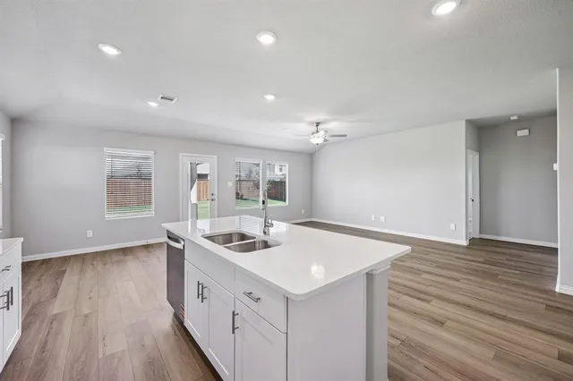 a kitchen that has a sink a stove and wooden floor