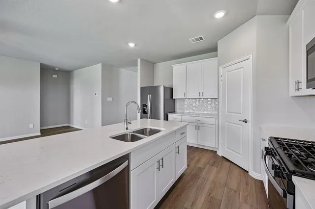 a kitchen with white cabinets and stainless steel appliances