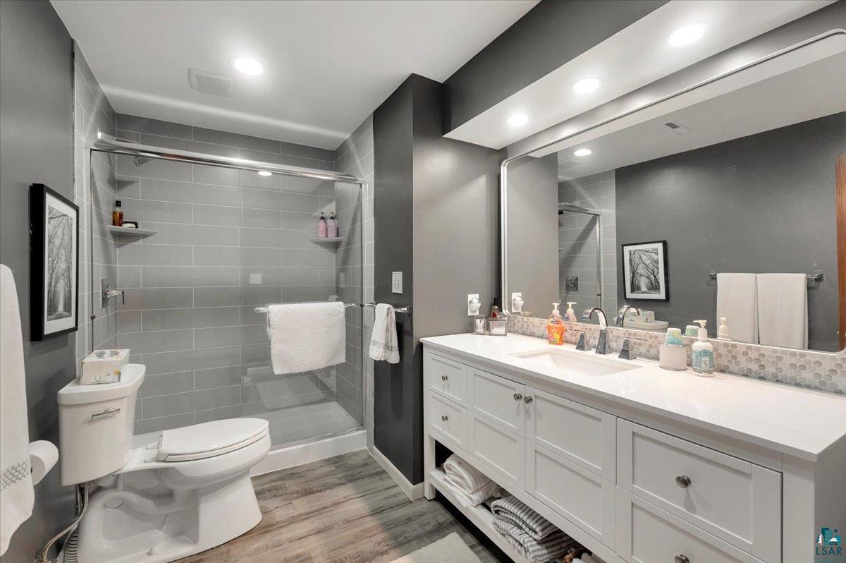 1323 South Ridge Road Duluth, MN 55804 - Photo 15 of 31 Bathroom featuring walk in shower, wood-type flooring, toilet, and vanity
