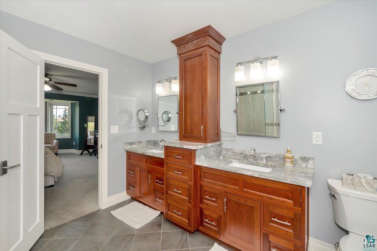 1323 South Ridge Road Duluth, MN 55804 - Photo 22 of 31 Bathroom featuring tile patterned flooring, dual vanity, toilet, and ceiling fan