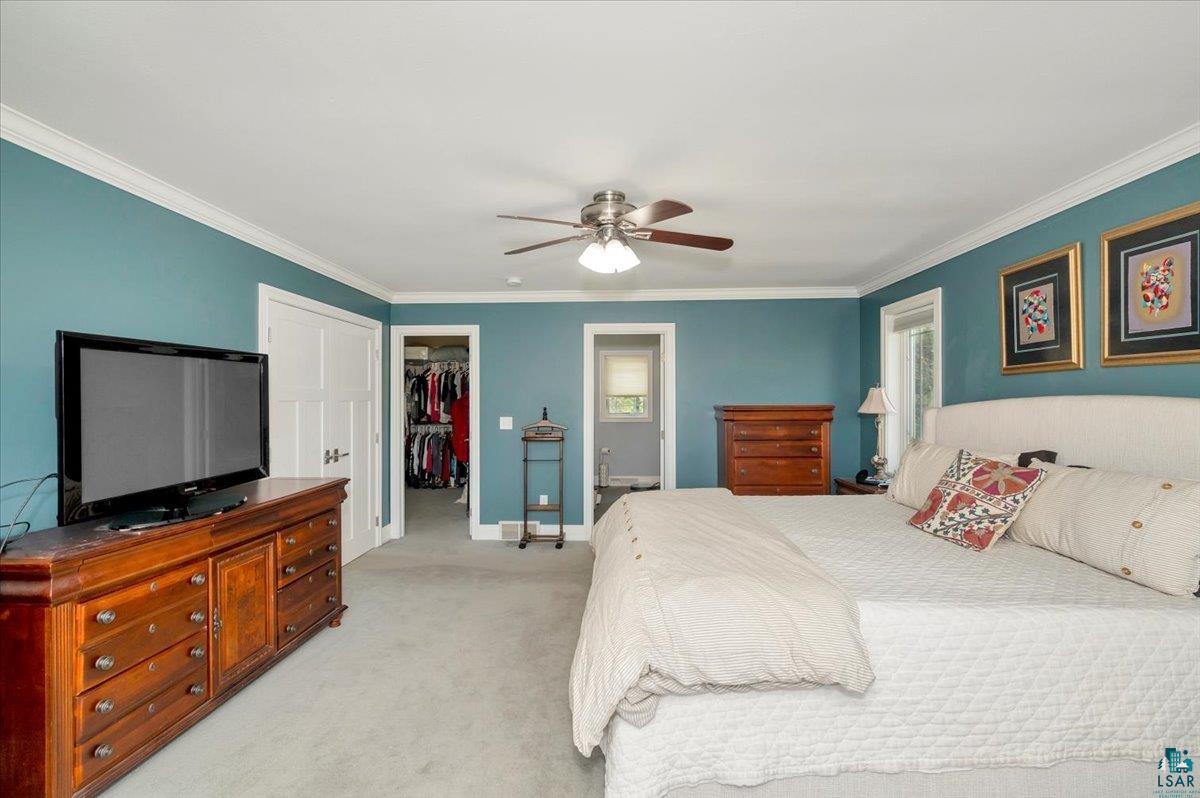 1323 South Ridge Road Duluth, MN 55804 - Photo 23 of 31 Carpeted bedroom with ensuite bathroom, a closet, crown molding, a walk in closet, and ceiling fan