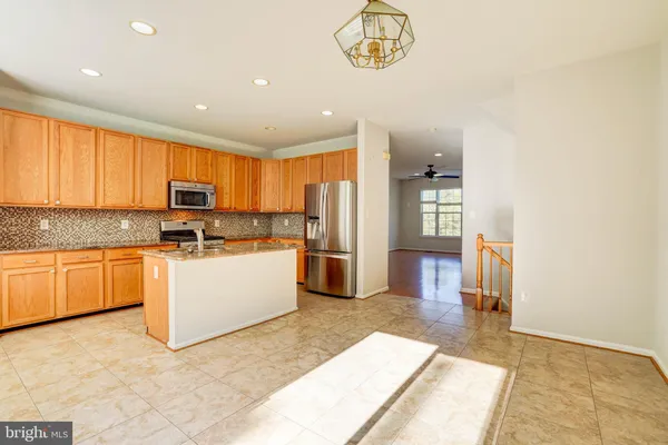 a kitchen with a refrigerator and a stove top oven