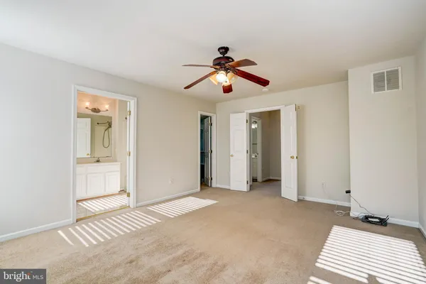 a view of a room with wooden floor and a ceiling fan