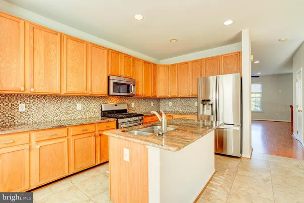 a kitchen with stainless steel appliances granite countertop a refrigerator stove microwave and sink