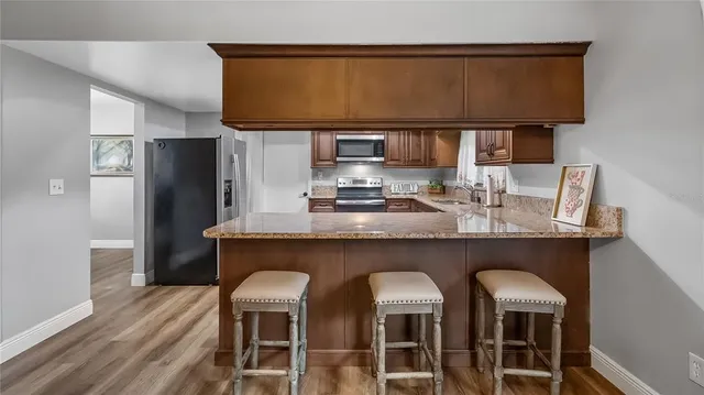 a kitchen with a wooden floor and chairs