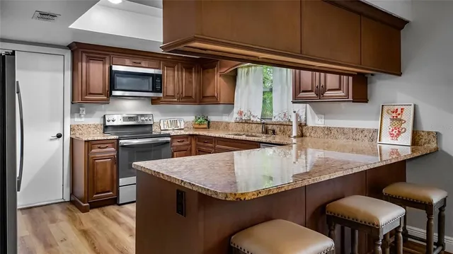 a kitchen with stainless steel appliances granite countertop a sink a stove and a microwave
