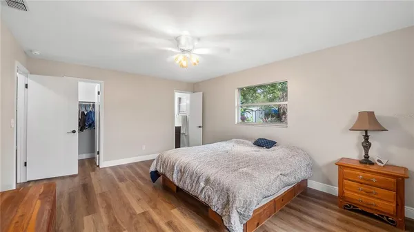 a bedroom with a bed and wooden floor