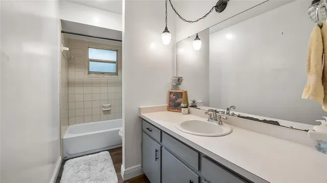 a bathroom with a sink vanity granite tub and a mirror