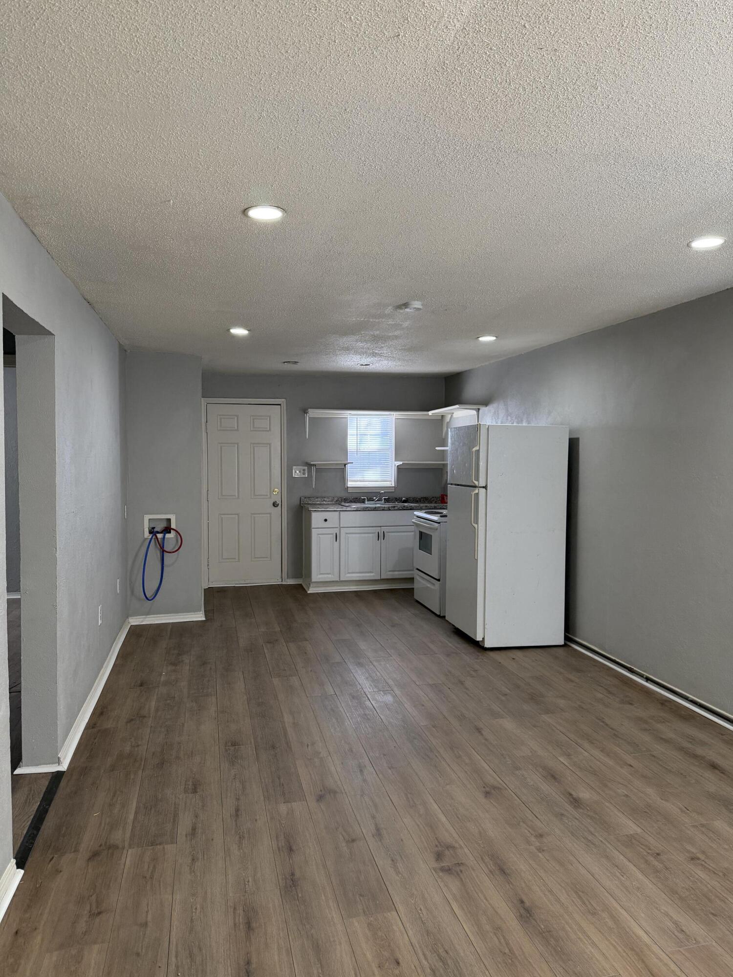 2605 1st Street Lubbock, TX 79415 - Photo 3 of 12 a view of an empty room with a kitchen