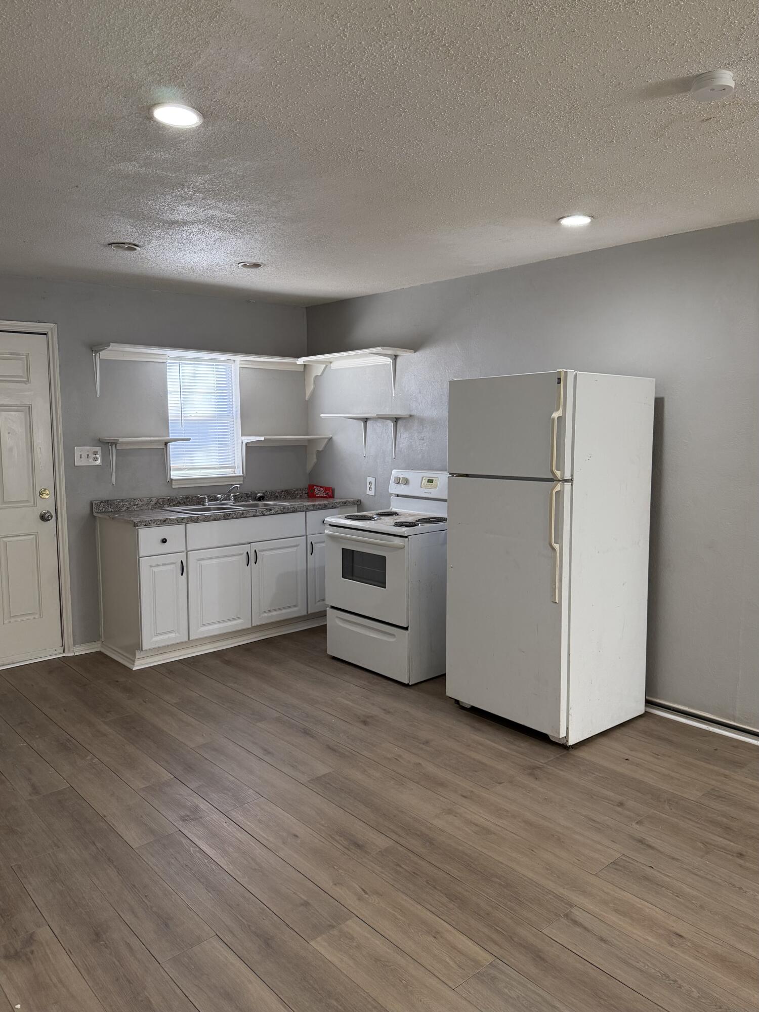 2605 1st Street Lubbock, TX 79415 - Photo 4 of 12 a kitchen with stainless steel appliances a refrigerator sink and cabinets